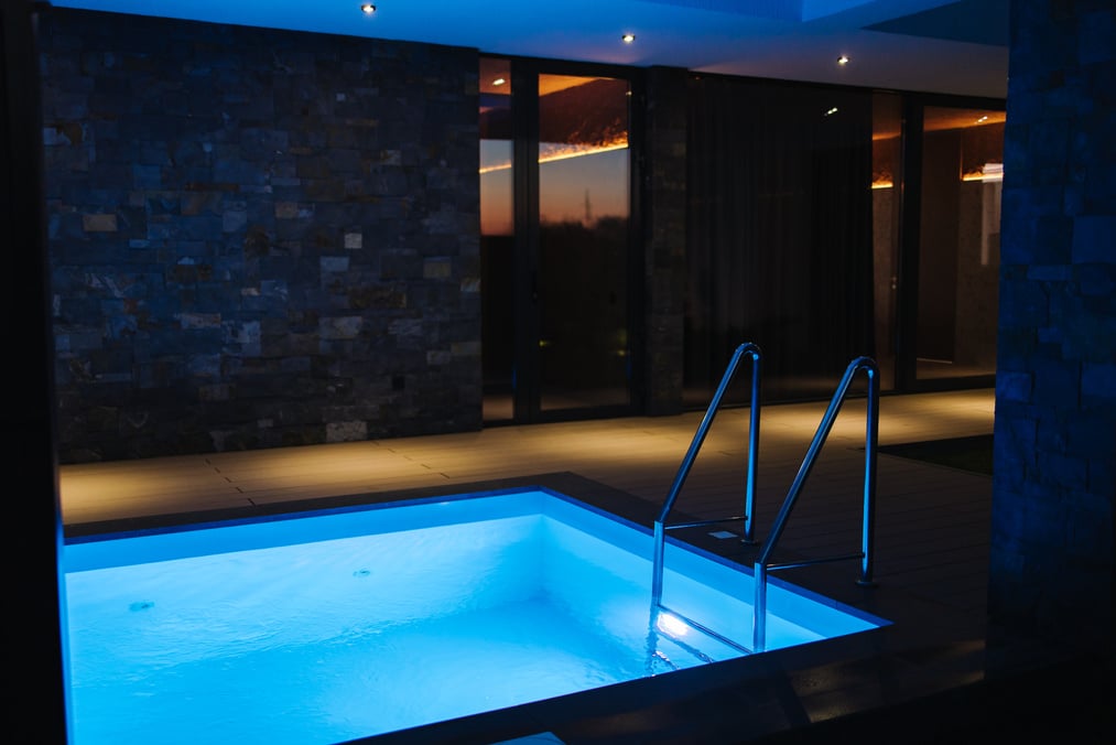 Plunge pool with cold water preparing after relaxing in sauna. Pool is filled with water. Evening photo with backlight